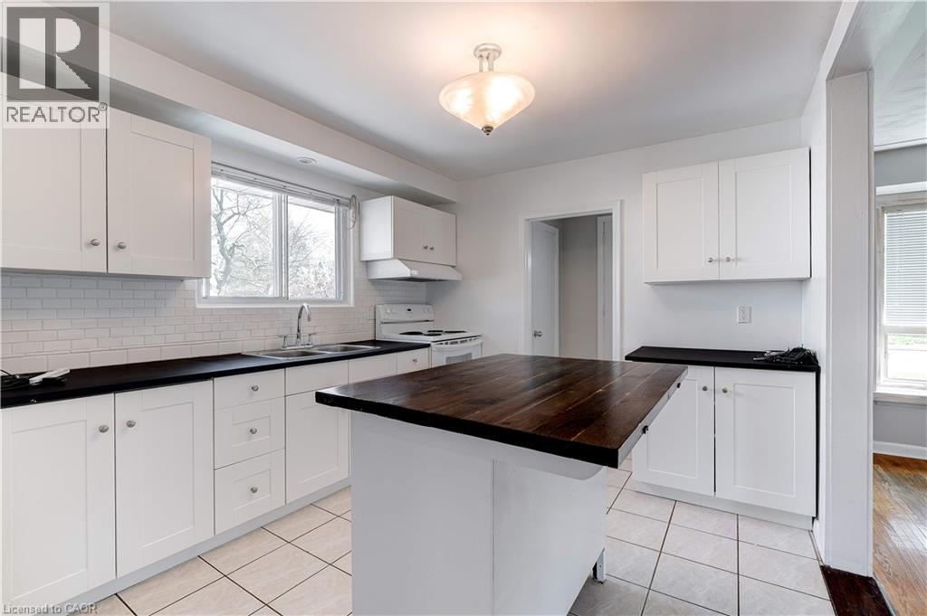 A kitchen with white cabinets and a wooden island.