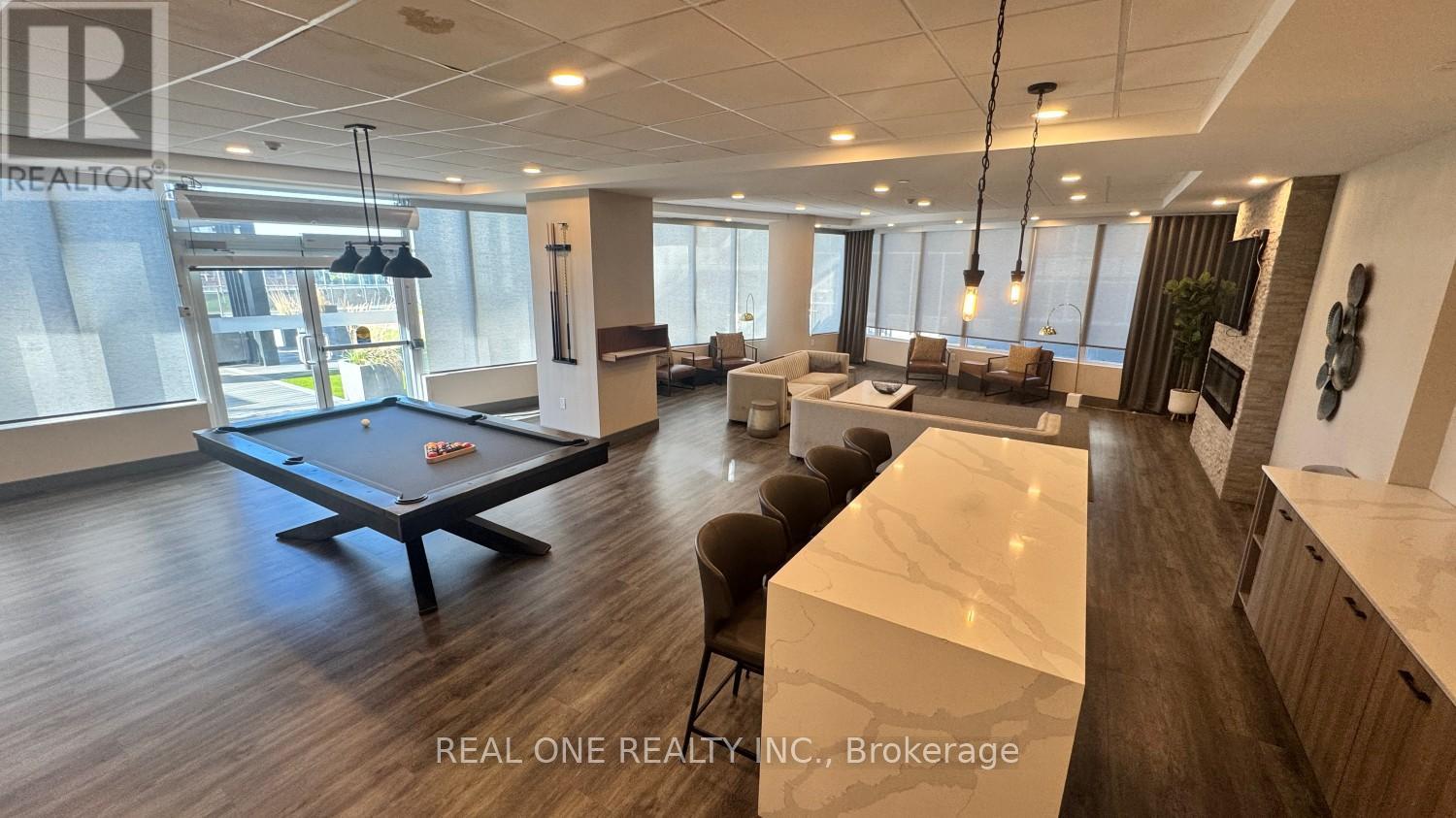 A billiard table is in the middle of a well-lit room with a pool table and a bar.