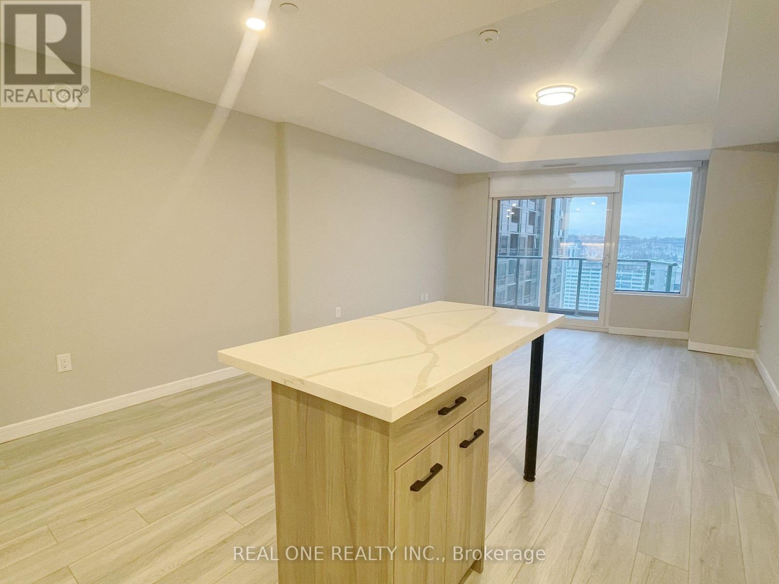 A spacious room with a desk and a window overlooking a cityscape.