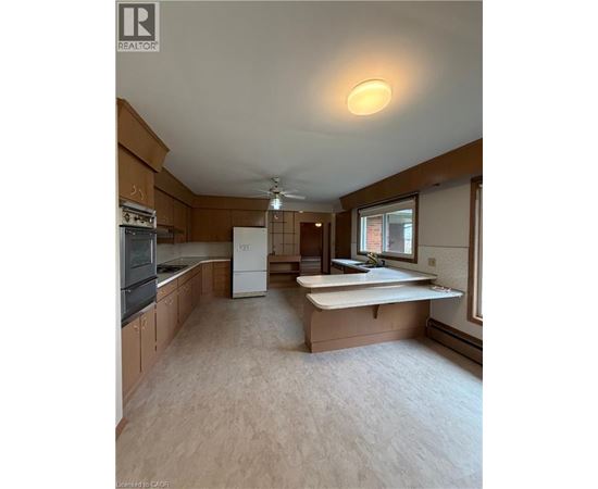 A kitchen with wooden cabinets and a white fridge.