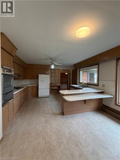 A kitchen with wooden cabinets and a white fridge.