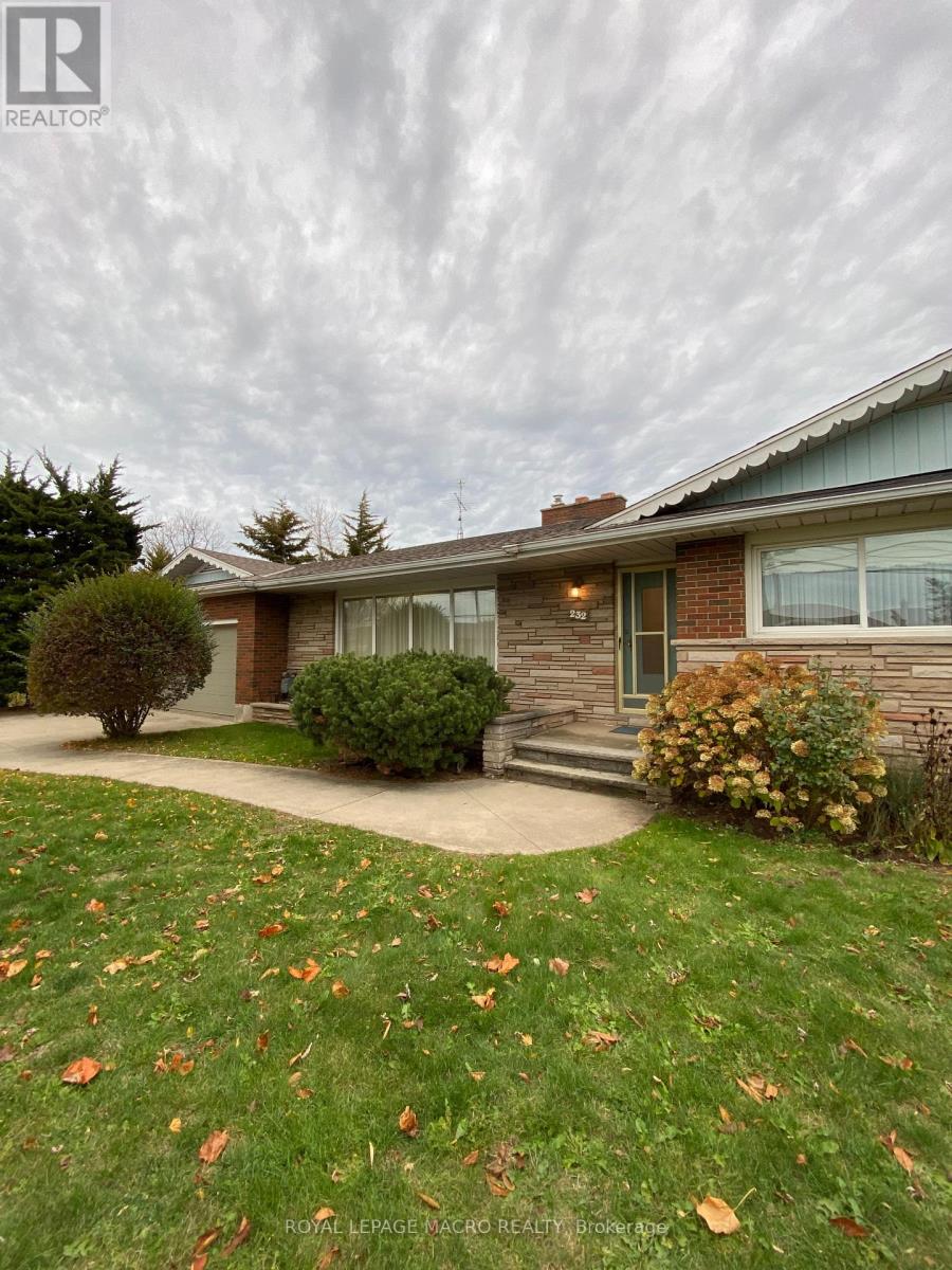 A house with a lawn and a tree in front of it.