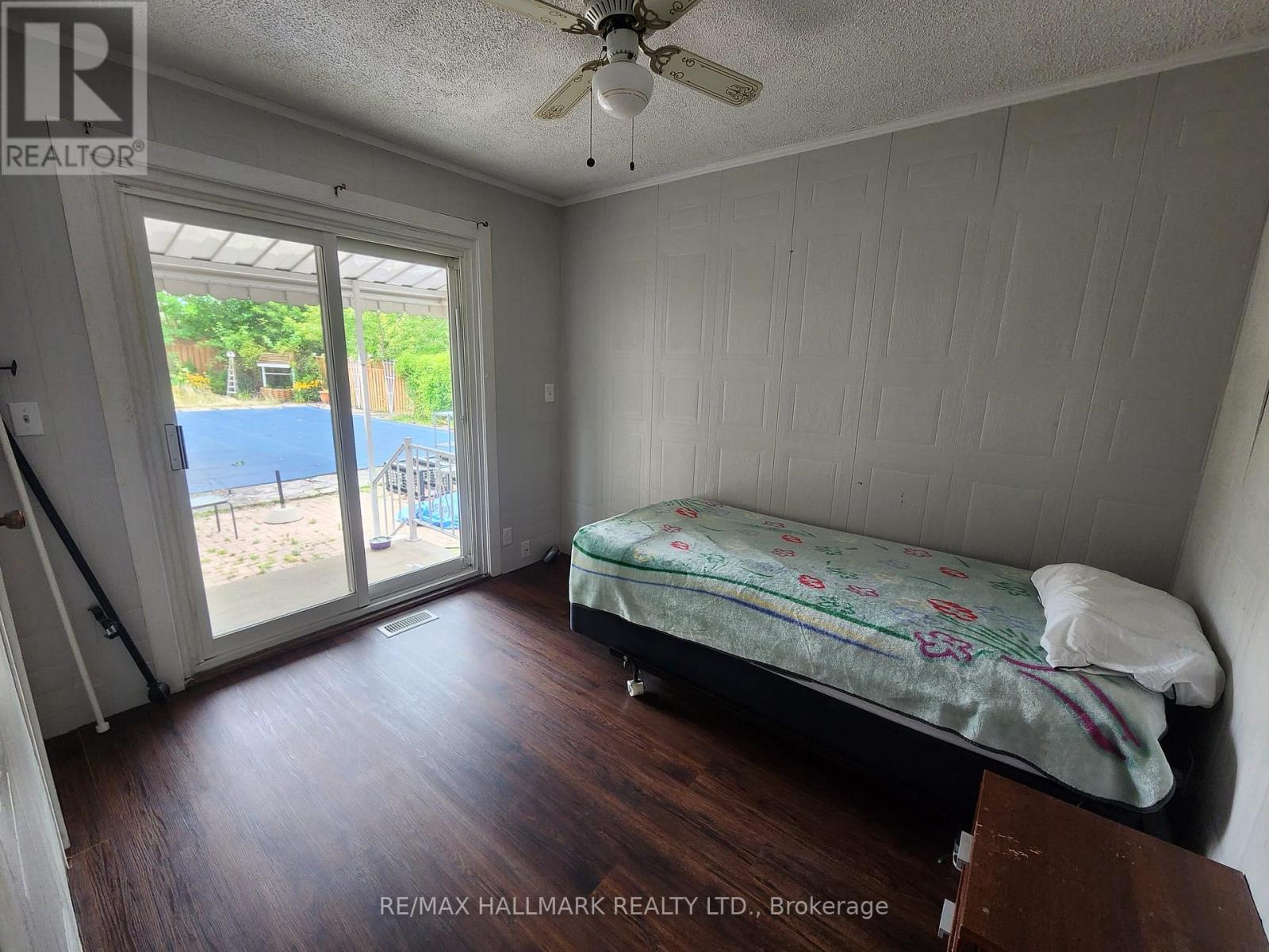 A bedroom with a bed and a ceiling fan.