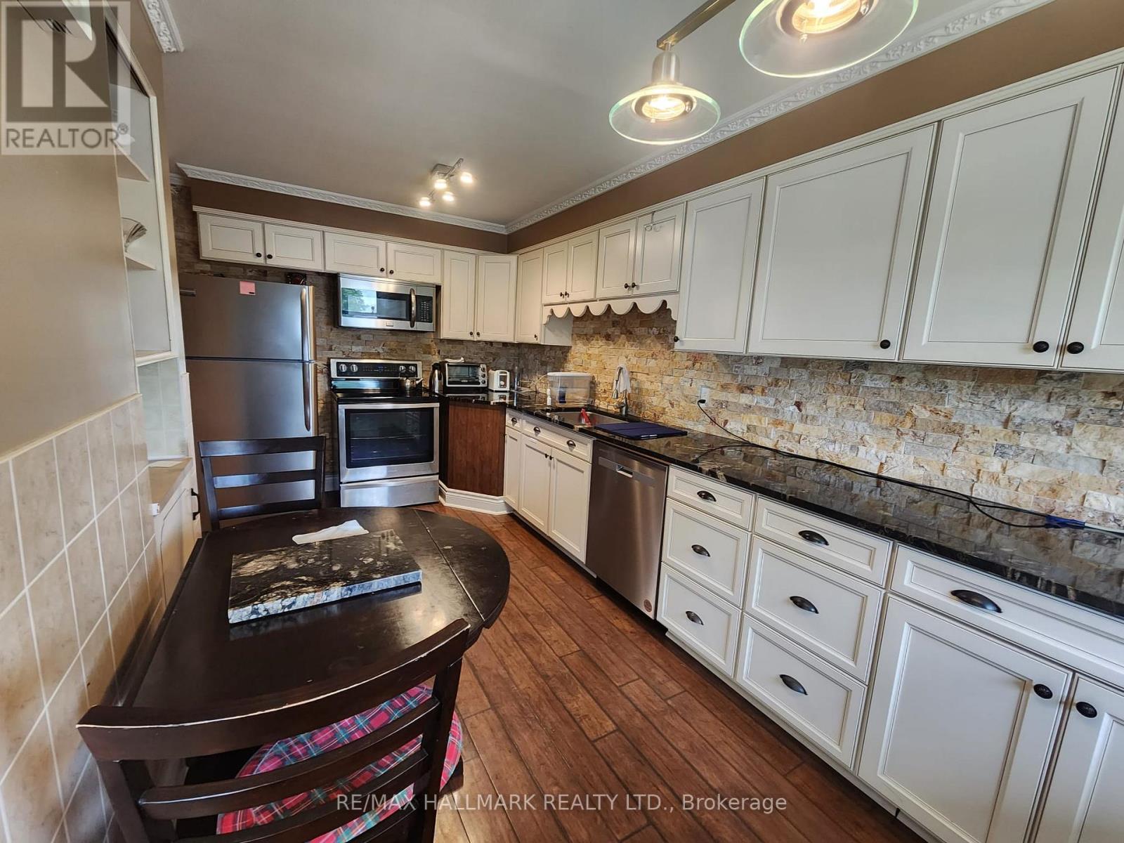 A kitchen with white cabinets and a black table.