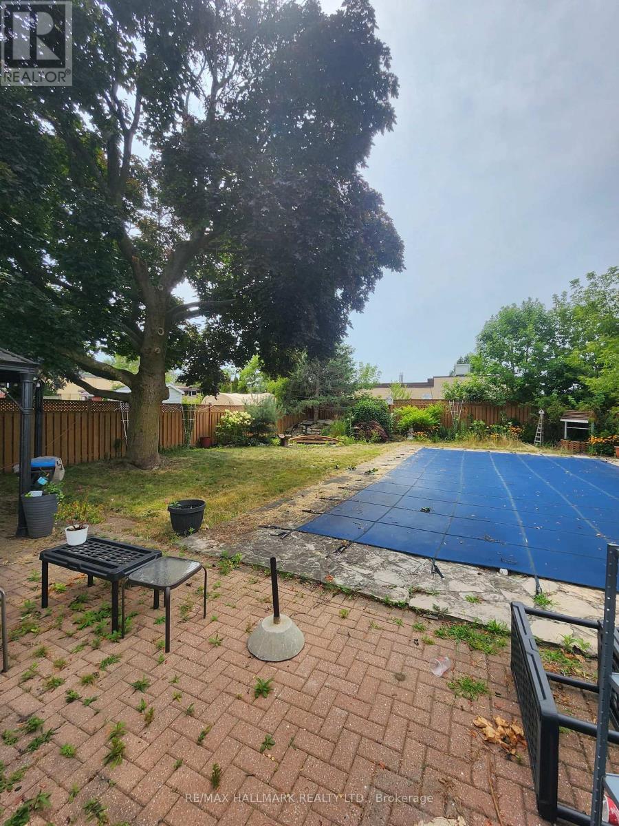 A backyard with a pool covered in a blue tarp.