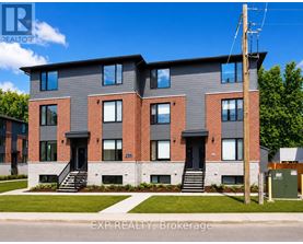 An aerial view of a multi-story apartment building with a parking lot in front.