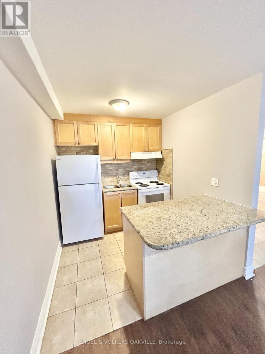 A kitchen with a white refrigerator, a countertop, and a stove top oven.