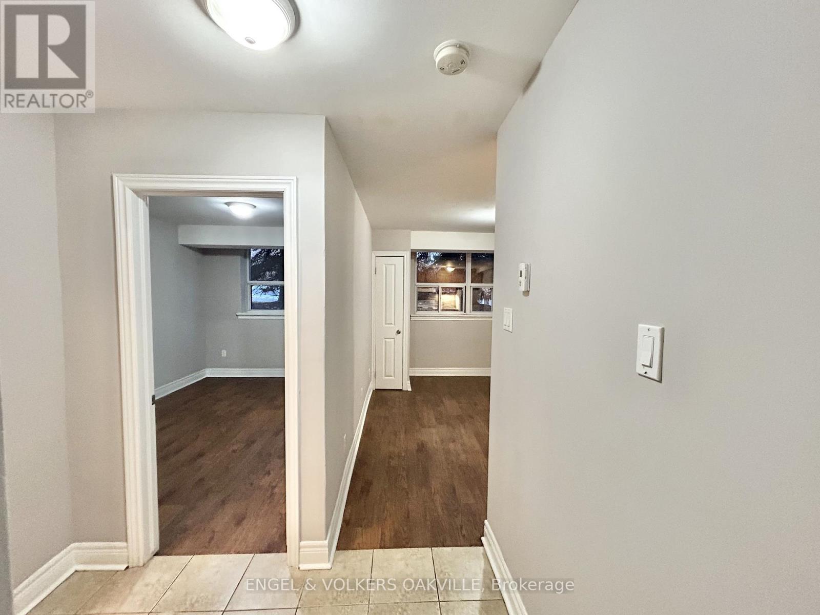 A room with wooden flooring and a window with blinds.