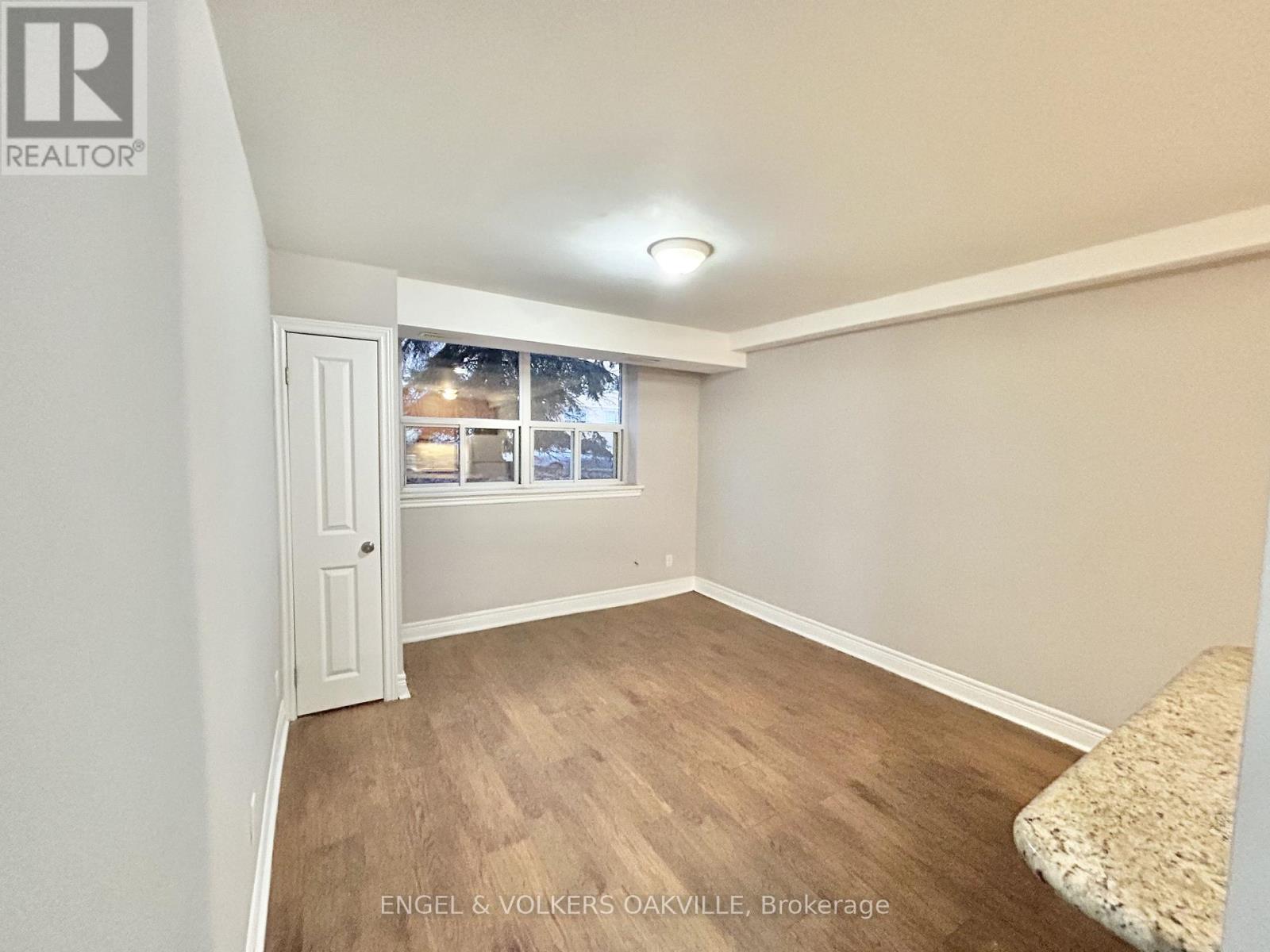 A hallway with tile flooring and white walls.