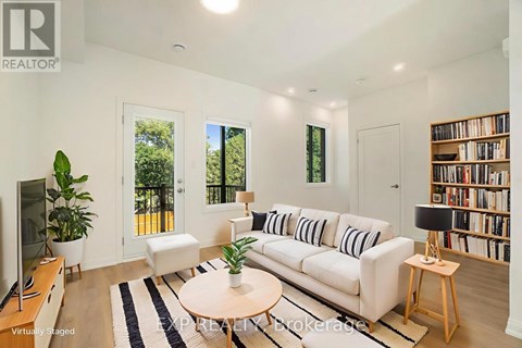 A living room with a white couch and a television.