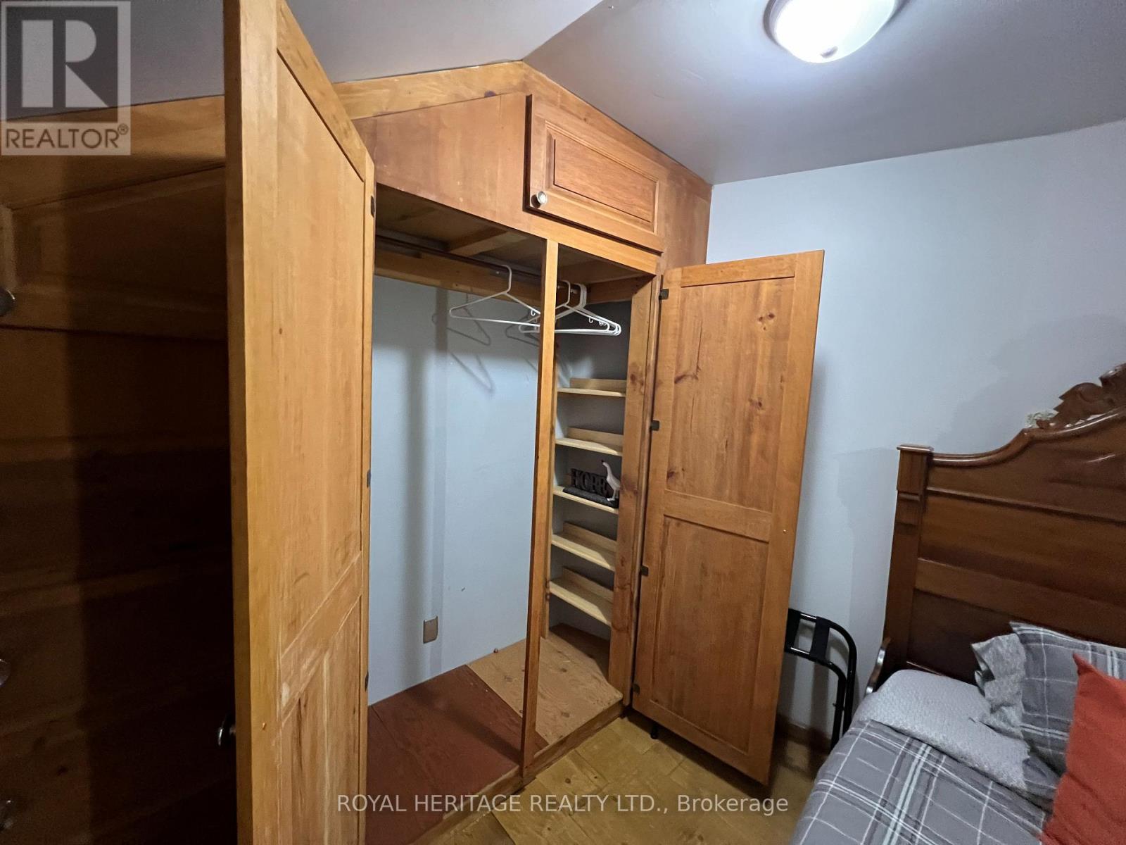 A bedroom with a bed, a wardrobe and a nightstand.