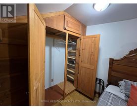 A bedroom with a bed, a wardrobe and a nightstand.