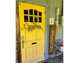 A yellow door with a sign that says "welcome".