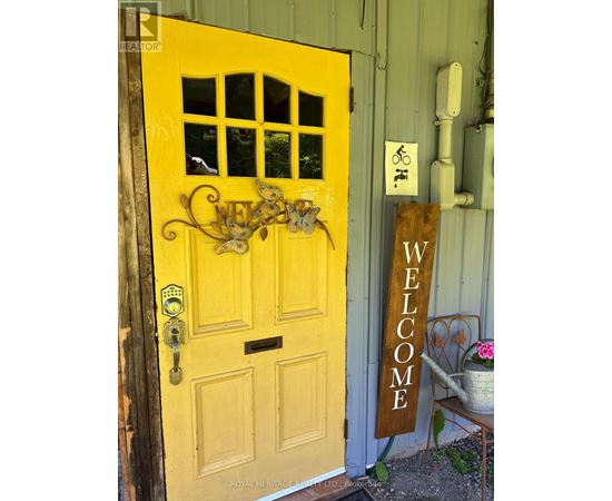 A yellow door with a sign that says "welcome".