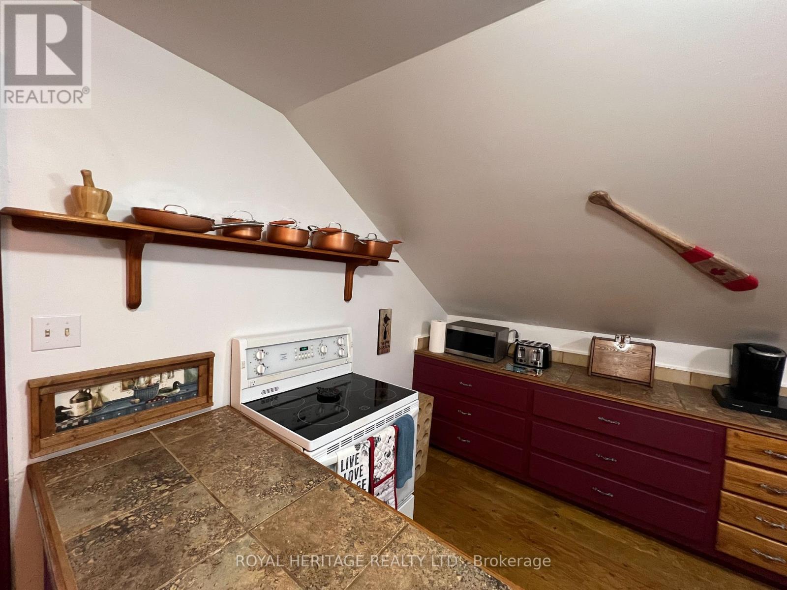 A kitchen with a stove top oven and a microwave on a counter.