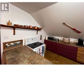 A kitchen with a stove top oven and a microwave on a counter.