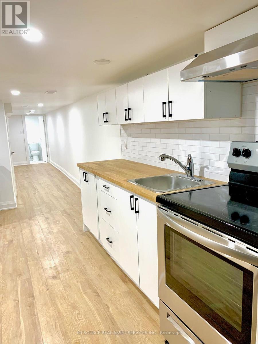 A modern kitchen with white cabinets and a wooden countertop.