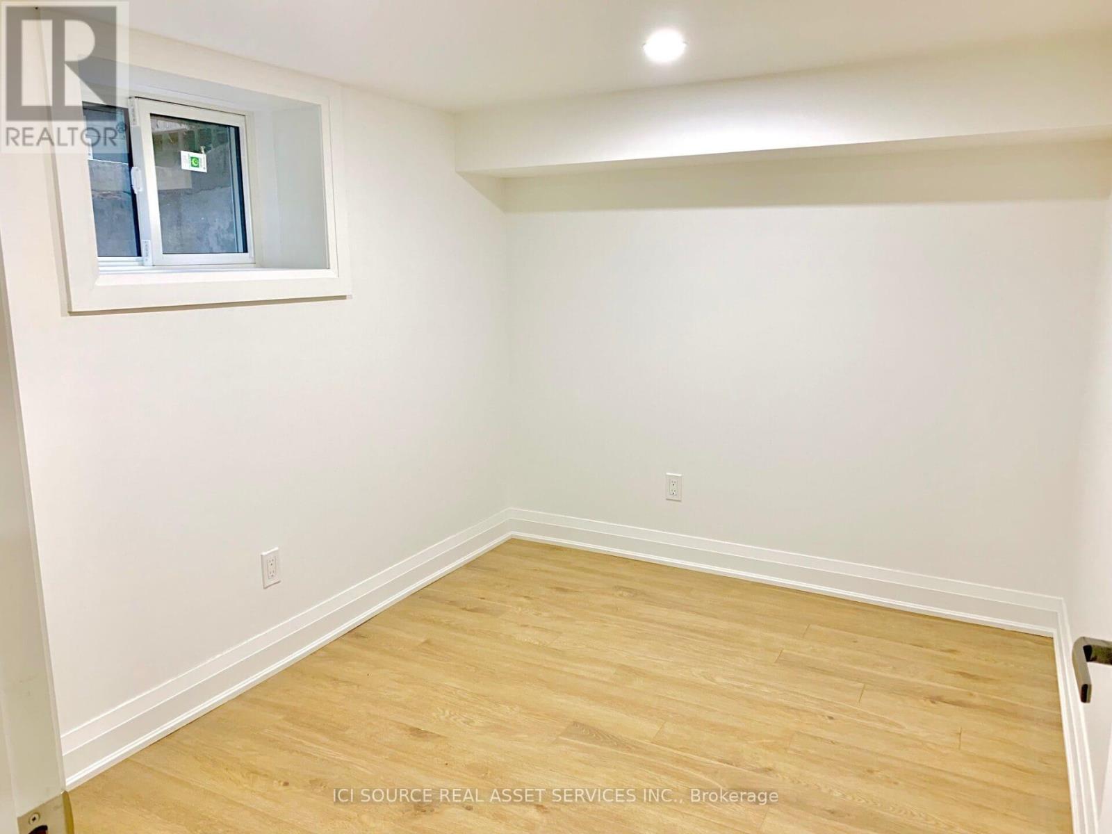 A room with a window and wooden flooring.