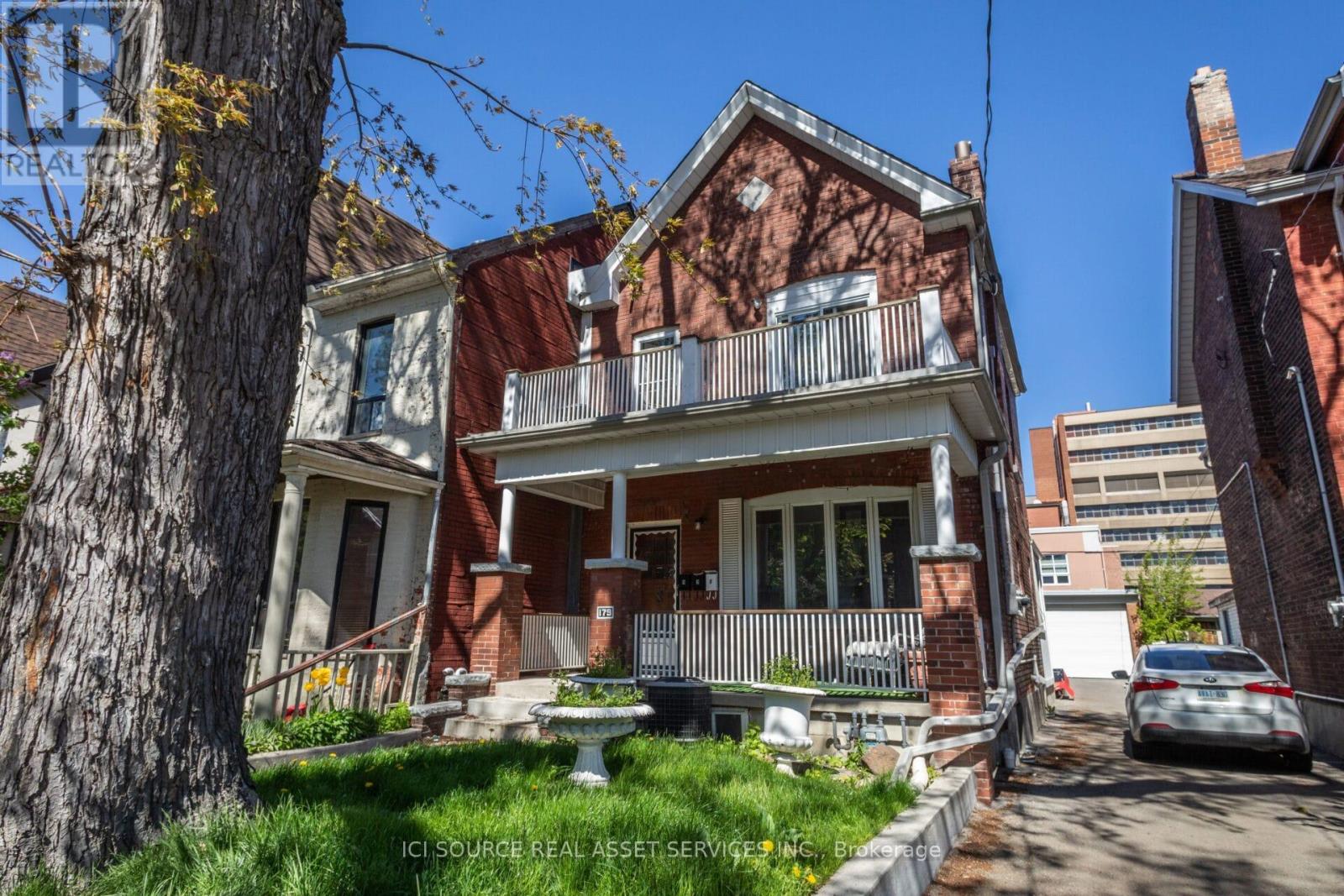 A house with a red brick facade and a white porch.