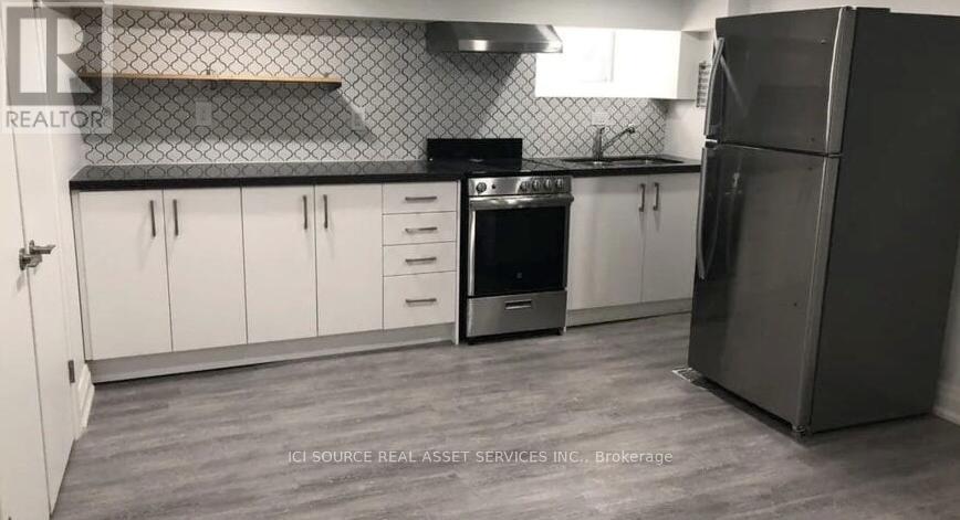 A kitchen with white cabinets and a black stove top oven.