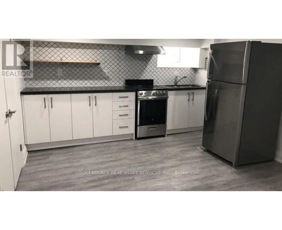A kitchen with white cabinets and a black stove top oven.