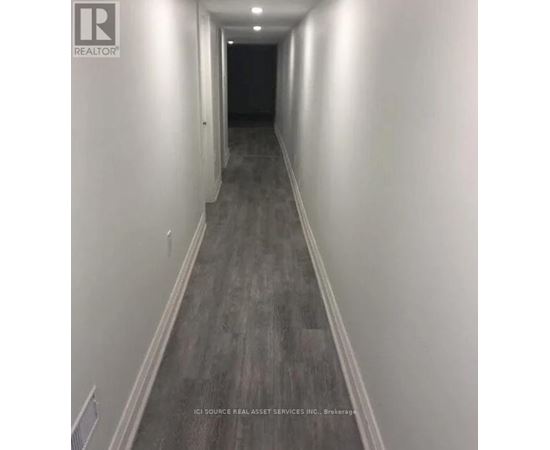 A long hallway with a light on the wall.
