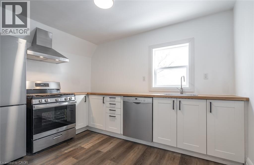 A kitchen with a stainless steel refrigerator, oven, and cabinets.