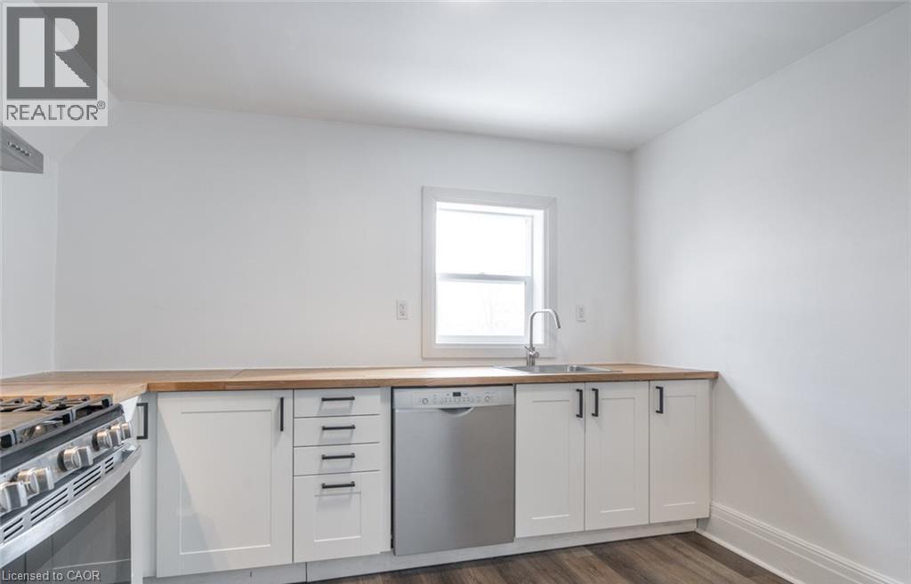 A kitchen with white cabinets and a window.
