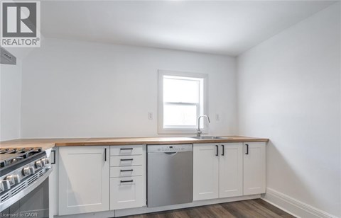 A kitchen with white cabinets and a window.