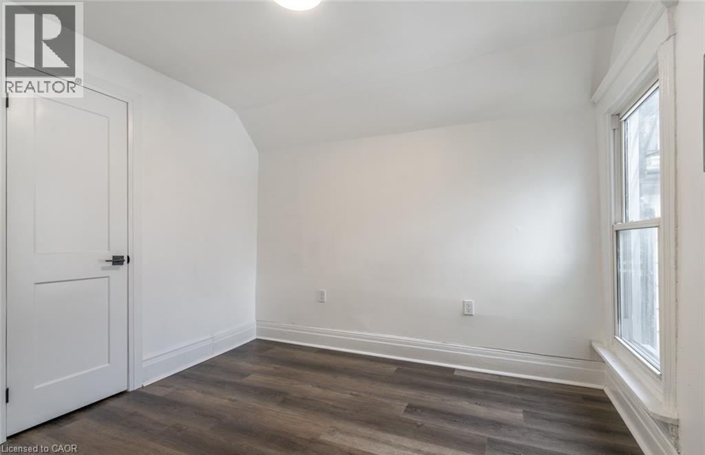 A room with a white door and a window with a wooden floor.