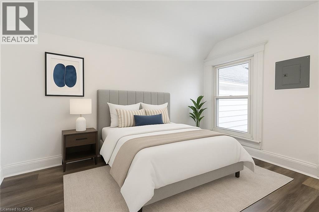 A bedroom with a large bed and a nightstand with a lamp.