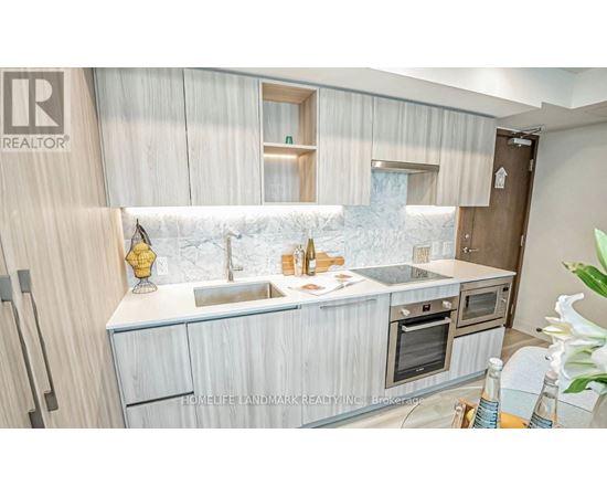 A modern kitchen with a marble backsplash and wooden cabinets.