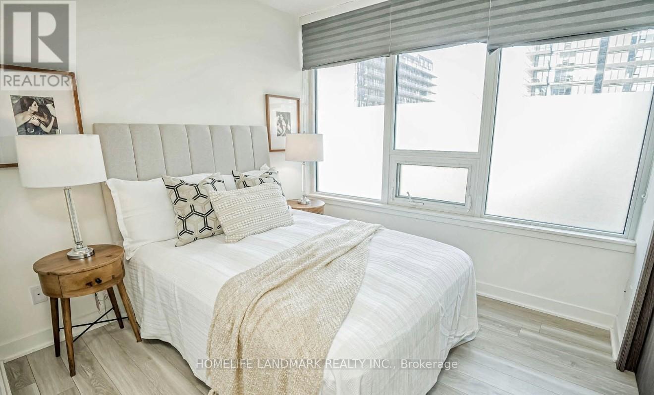 A bedroom with a large bed and a window with blinds.