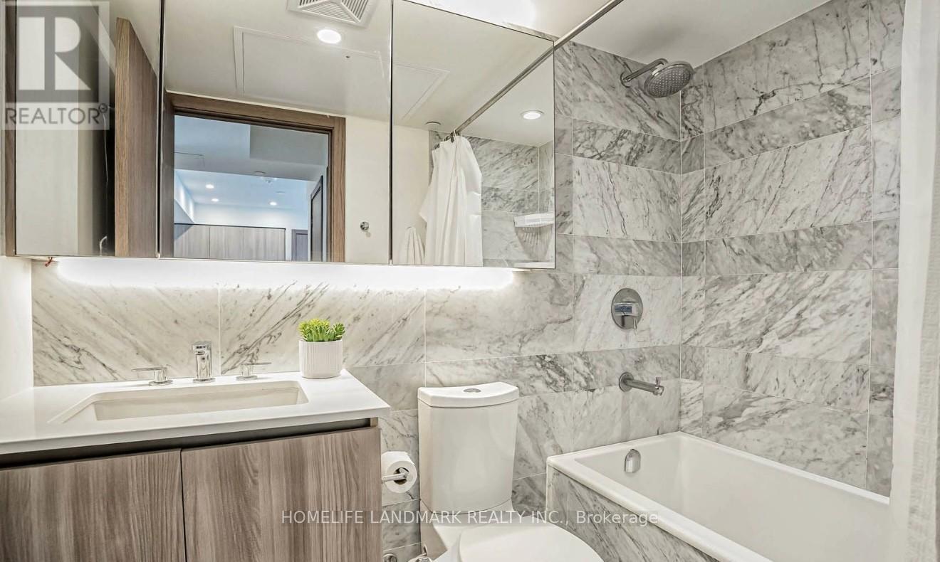 A bathroom with marble walls and a tub.