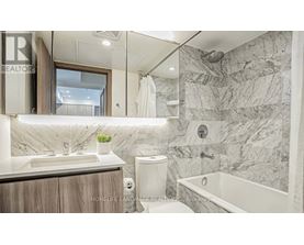 A bathroom with marble walls and a tub.