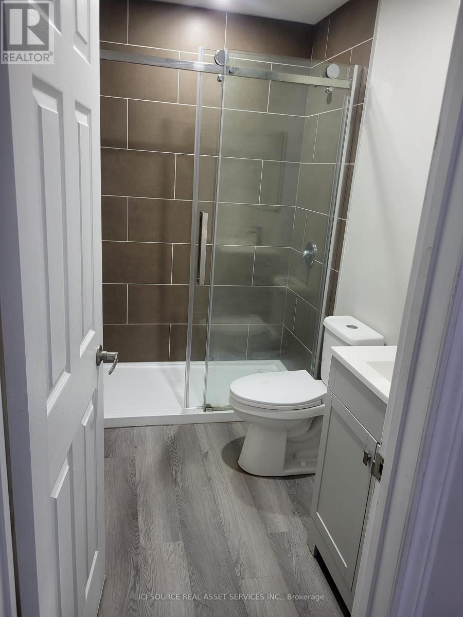 A bathroom with a toilet, sink, and shower.