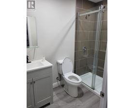 A bathroom with a toilet, sink, and shower.