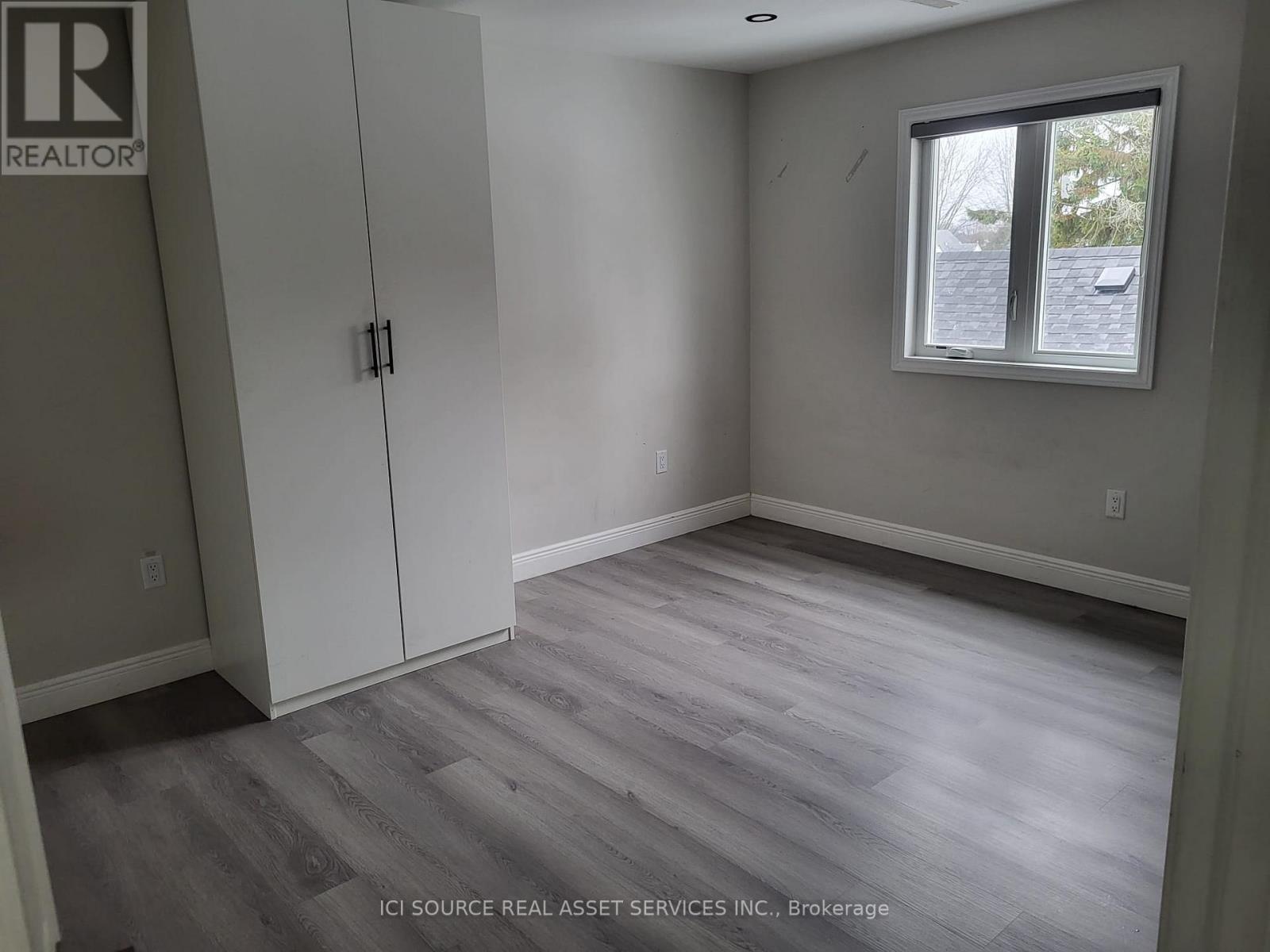 A room with a grey floor and a window.