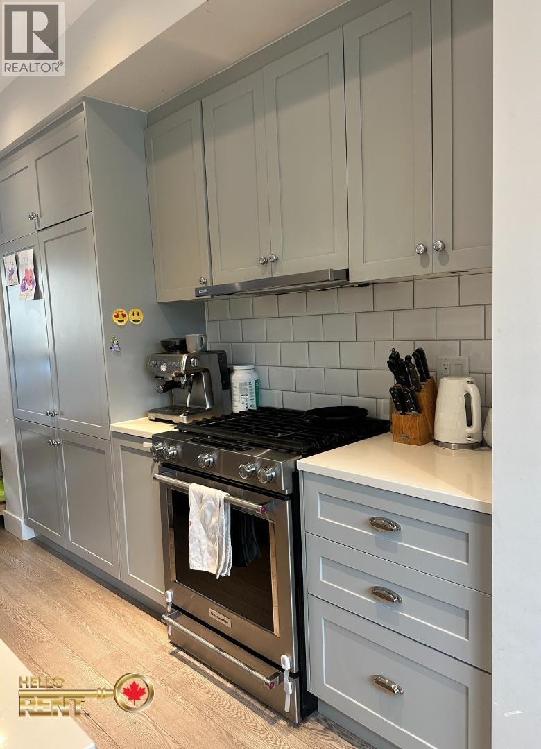 A kitchen with a black stove top oven and a white toaster on the counter.