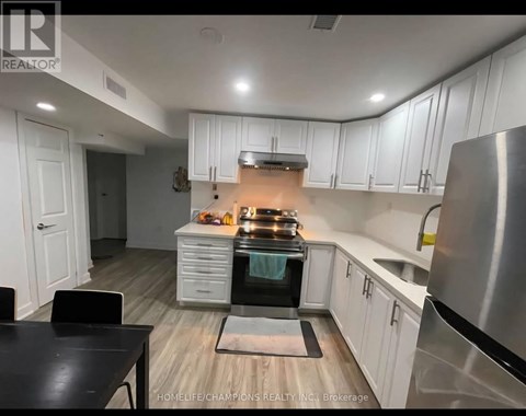 A modern kitchen with white cabinets and stainless steel appliances.