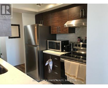 A kitchen with a refrigerator, microwave, oven, and stove.