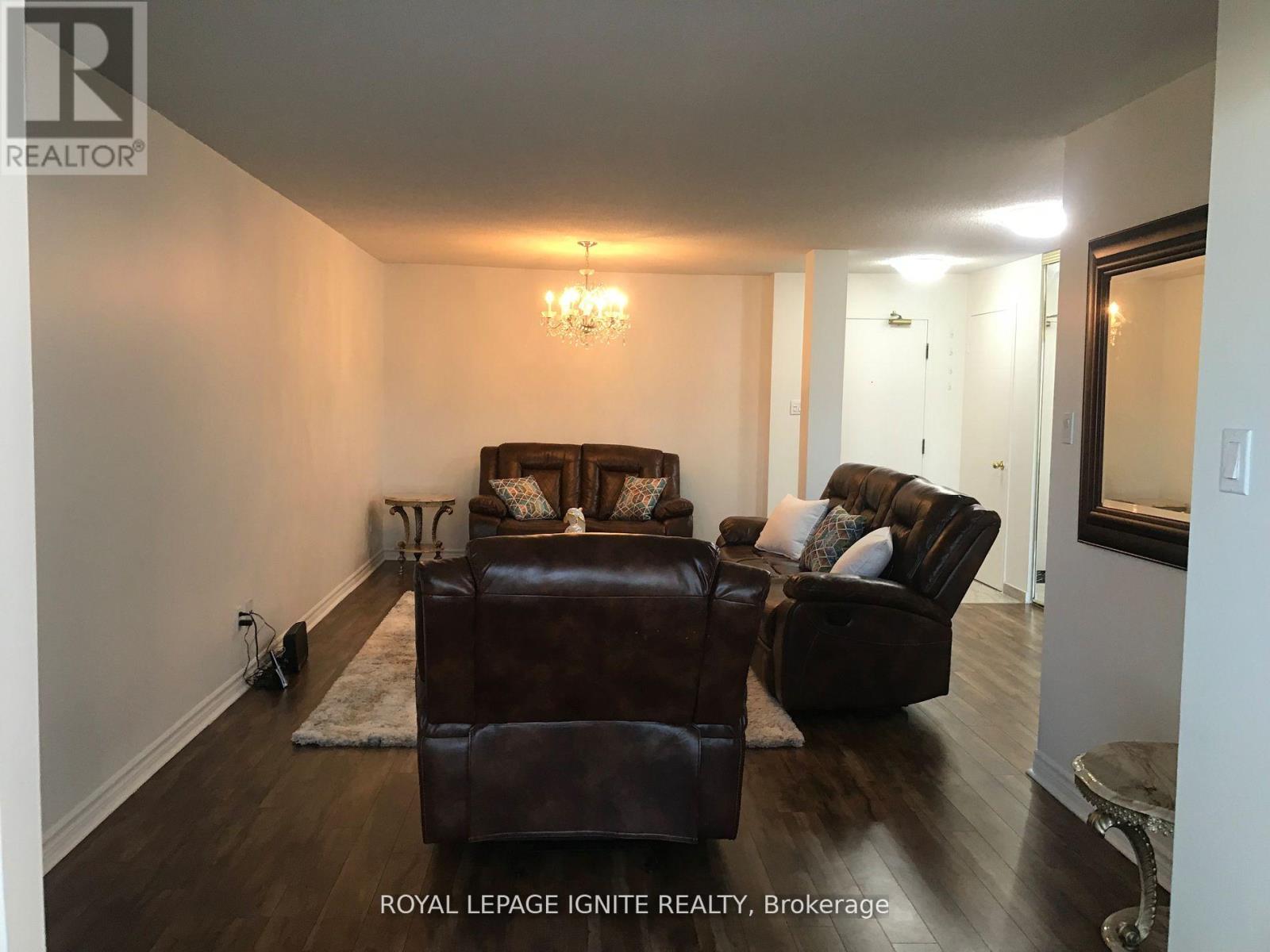 A living room with a brown leather couch and ottoman.