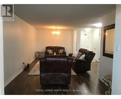 A living room with a brown leather couch and ottoman.