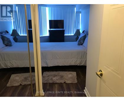 A bedroom with a bed, nightstand, and lamp.