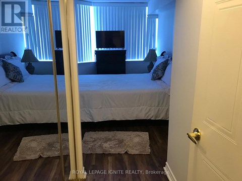 A bedroom with a bed, nightstand, and lamp.