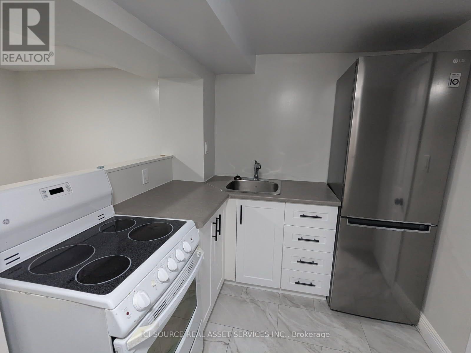 A kitchen with white appliances and cabinets.