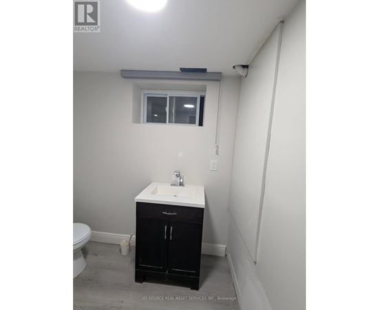 A bathroom with a sink, toilet, and cabinet.
