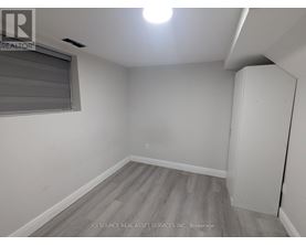 A room with a grey floor and a window with blinds.