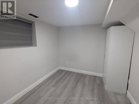 A room with a grey floor and a window with blinds.