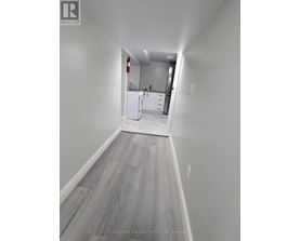 A long hallway with a kitchen in the distance.